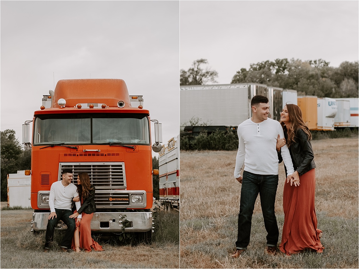 couple sitting on a semi truck and playfully frolicking in a semi truck field 