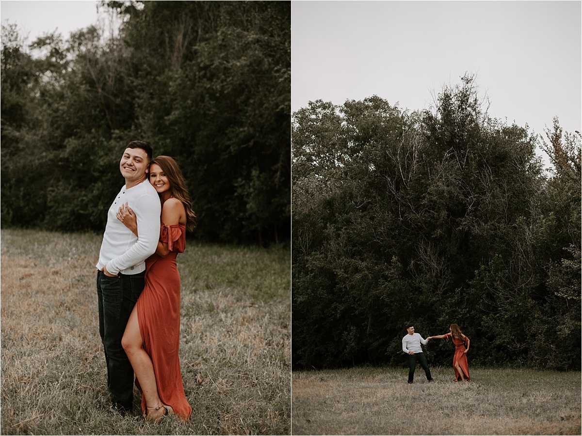 girl in an orange dress dancing during engagement session in a meadow