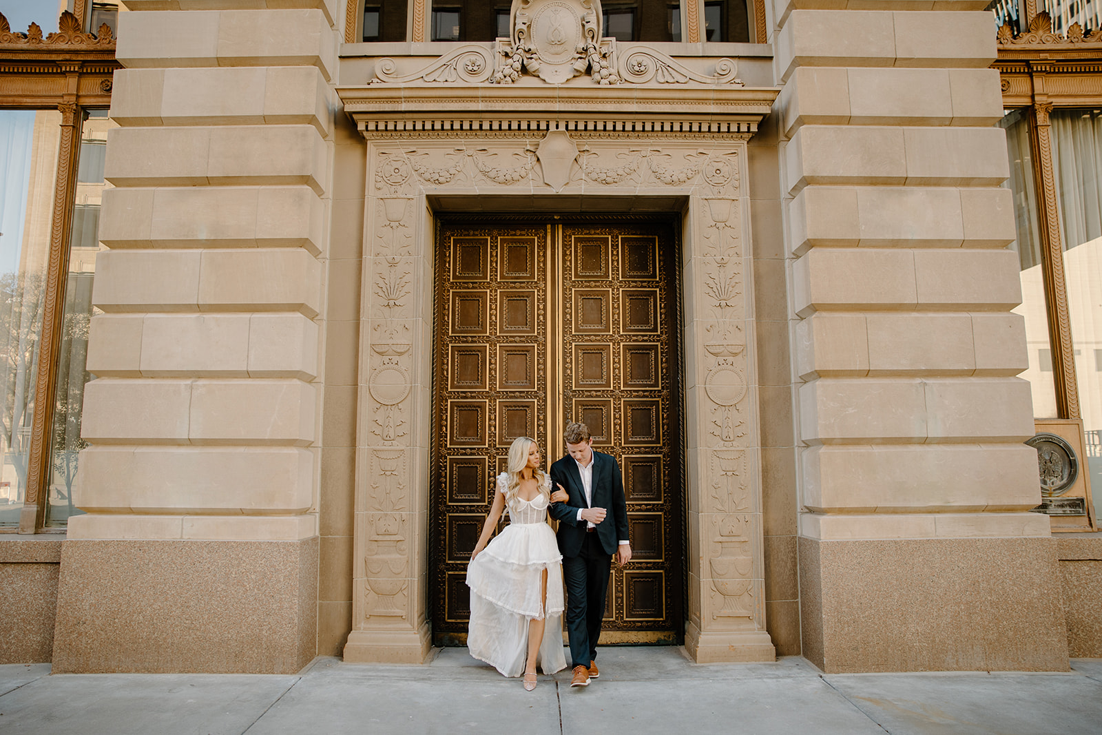 engaged couple standing in front of historic building doors